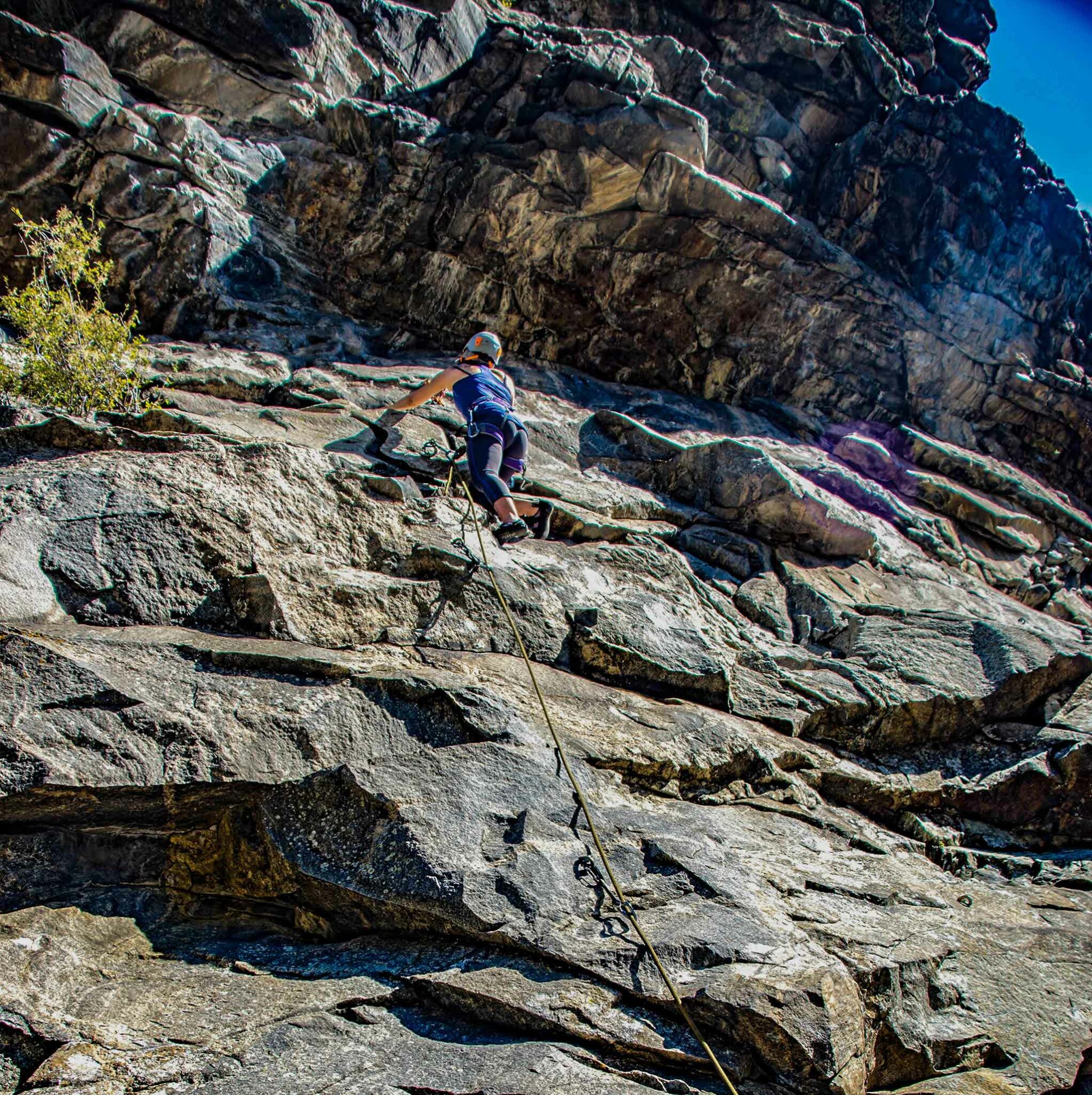 New sport climber embarking on their first lead climb including clipping bolts and topping out.