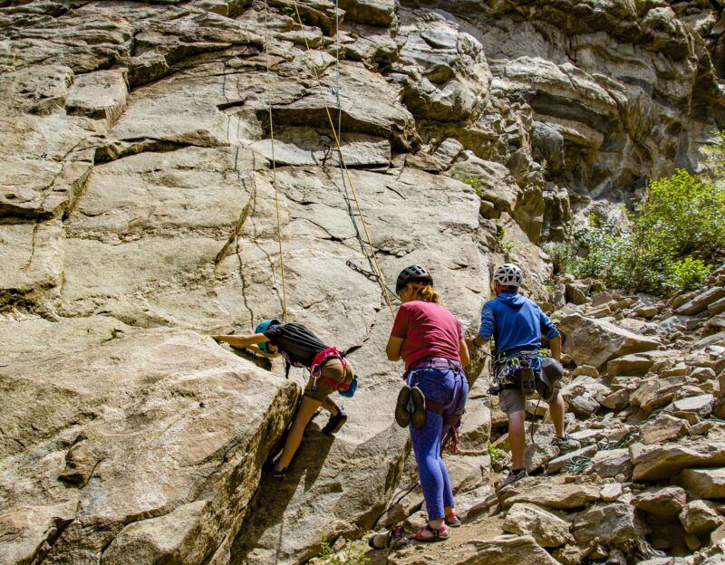 New climber belaying another novice during an introductory rock climbing lesson.