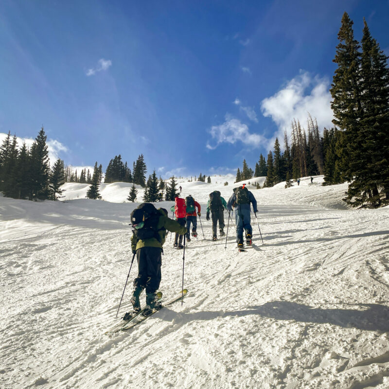 AIARE Level 1 participants skiing uphill during an avalanche training course