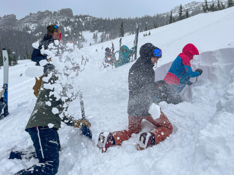 AIARE Level 1 students practicing avalanche rescue techniques in the snow.