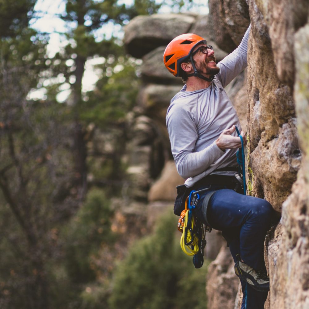 AMGA guide Dan demonstrating proper technique for clipping a bolt in a lead sport climbing course.